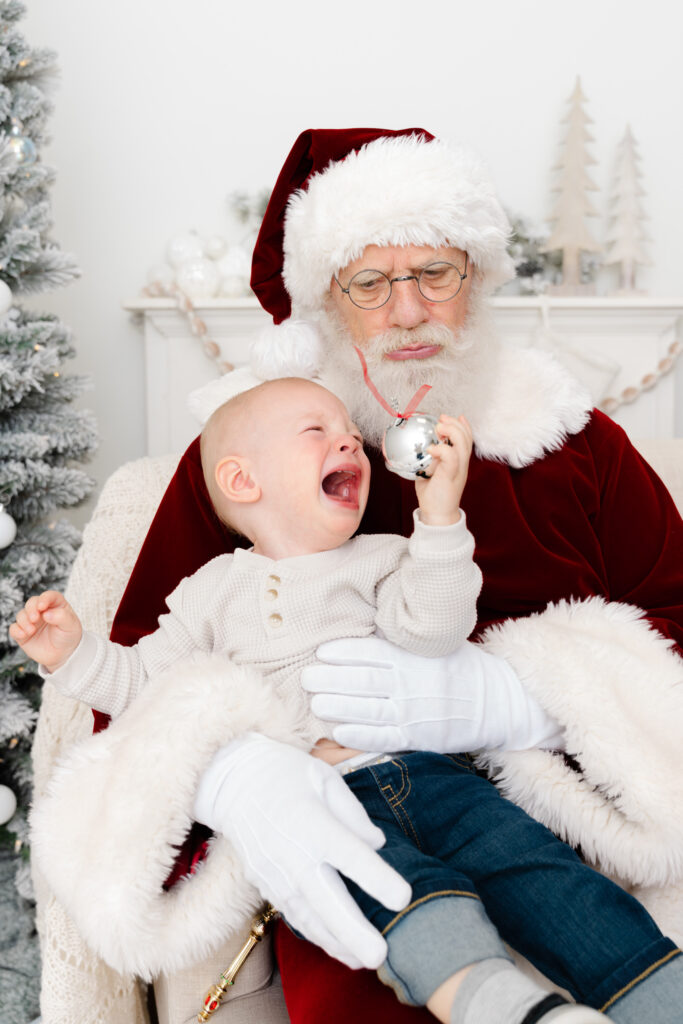 Baby crying with Santa Claus Holiday Sessions