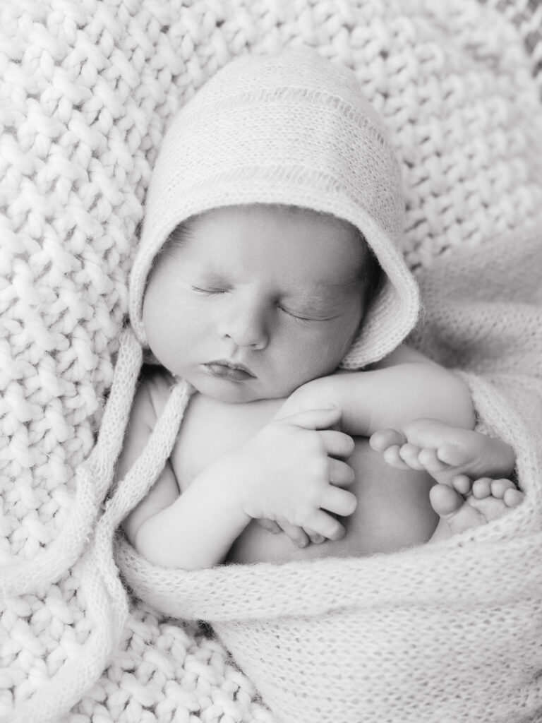 Close-up of newborn baby boy’s face with natural light and soft tones