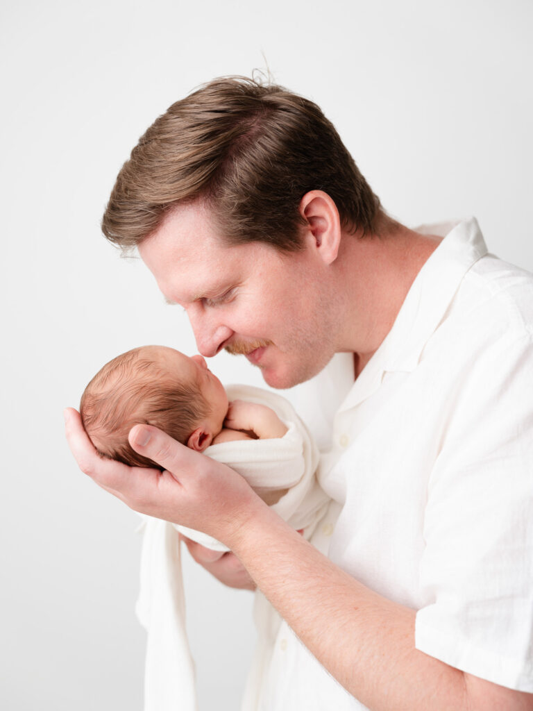 Baby wrapped in neutral swaddle during baby-led newborn session