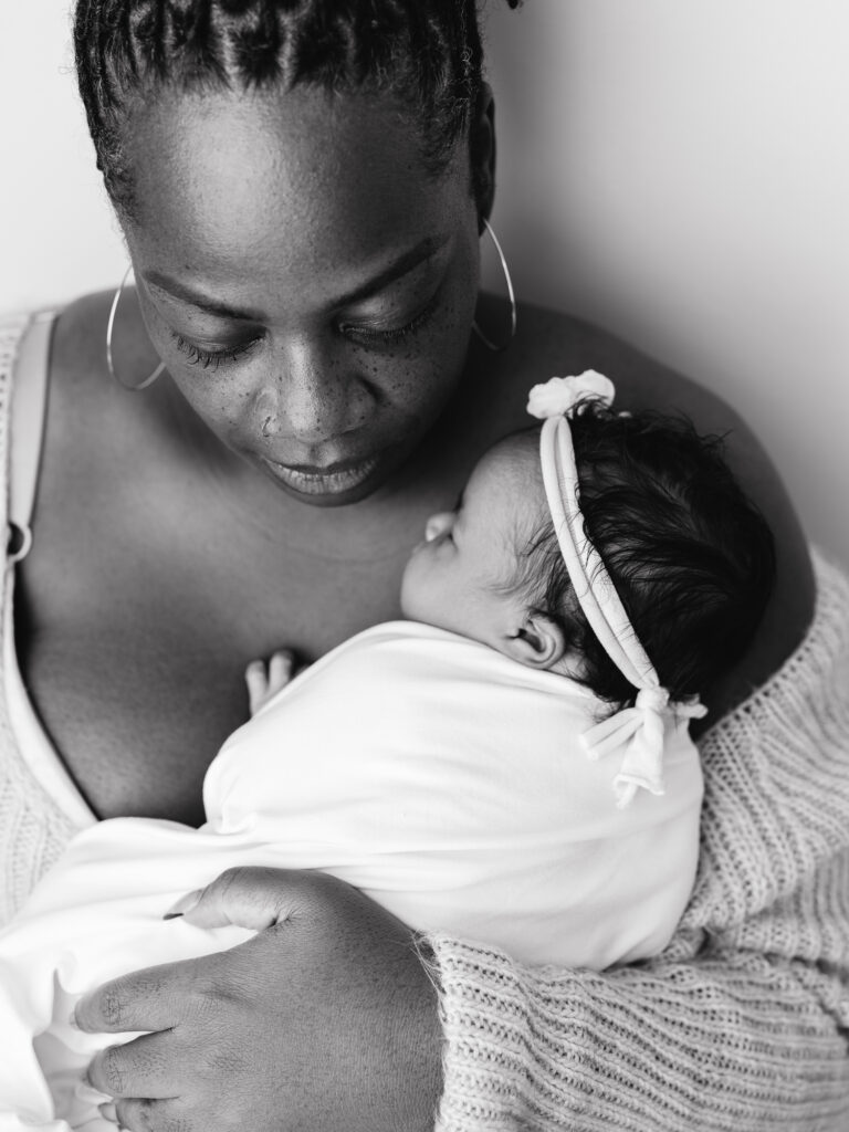 Black and white motherhood portrait of a mother holding her newborn baby in a Sacramento photography studio