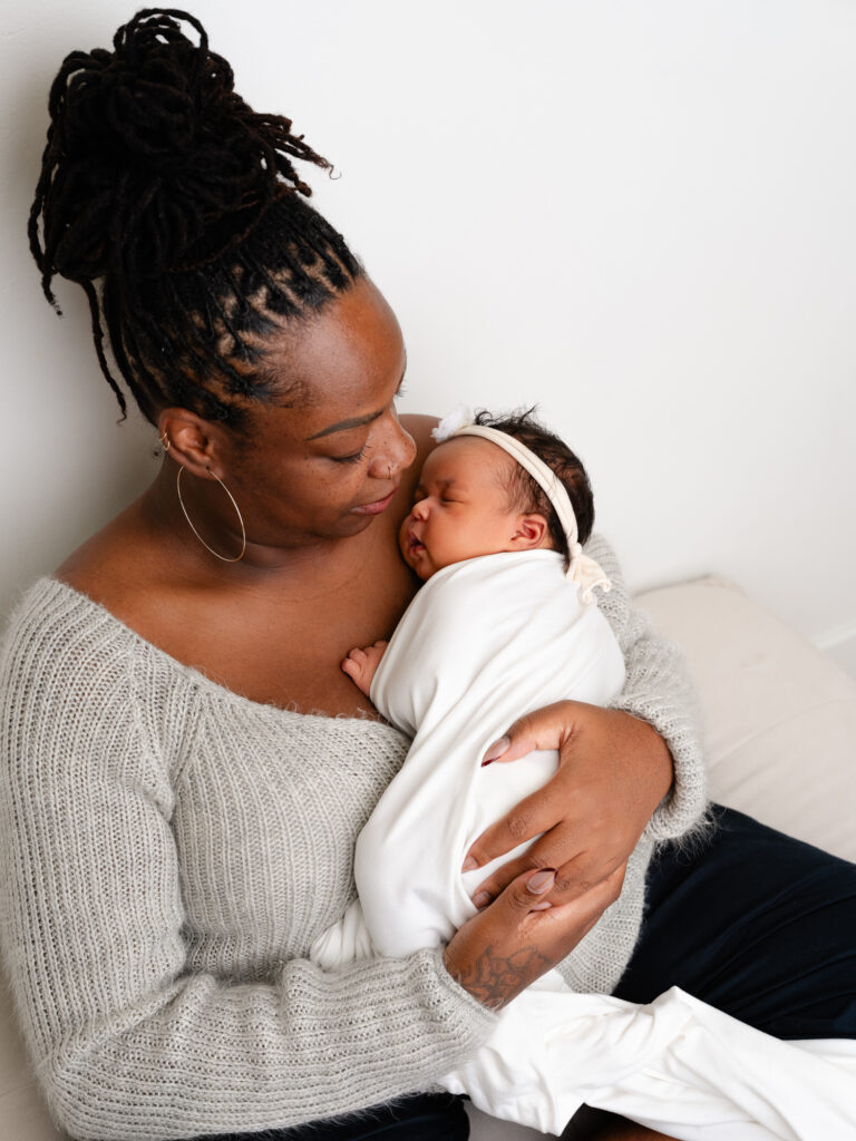 surrogate sharing a quiet moment with their newborn during a heartfelt family portrait session