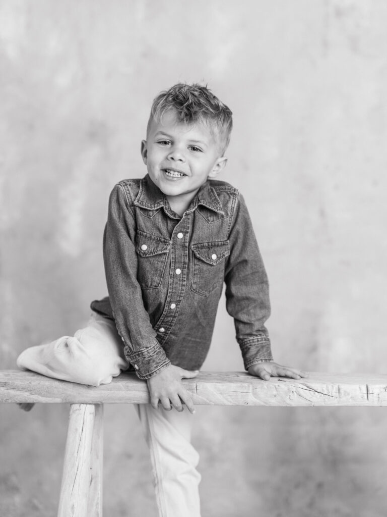 Black and white fine art portrait of a young boy photographed naturally in a studio.