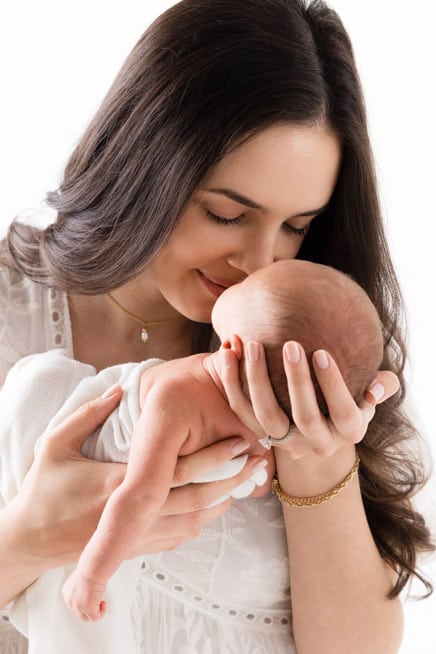 Mother holding newborn baby tenderly by Sacramento Newborn & Family Photographer Sweet Jean.
