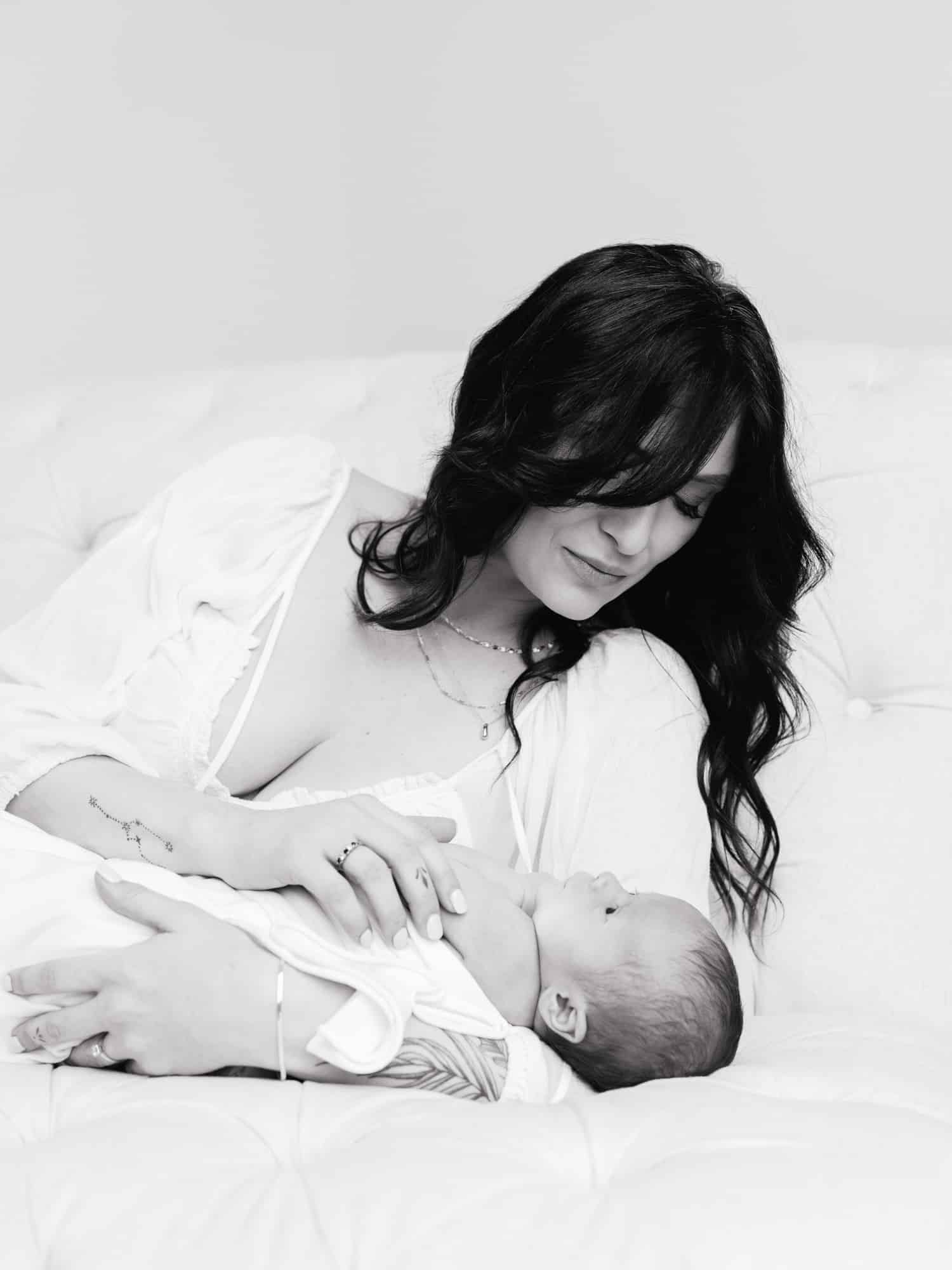 Soft, emotional portrait of mother and newborn baby boy in neutral tones during Roseville studio session